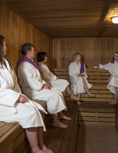 People relaxing in a sauna wellness space.
