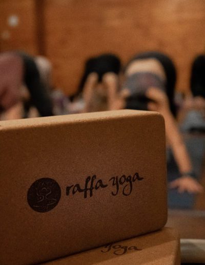 Yoga block on studio floor, in the foreground of class.