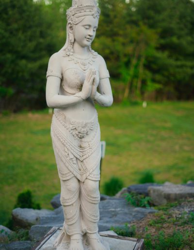 Statue of a traditional Apsara dancer, hands pressed together in a gesture of greeting or prayer