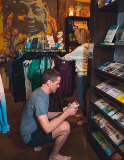 Man browsing wellness books in yoga studio shop.