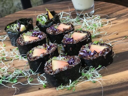 Vegetable sushi rolls with black rice and sprouts.